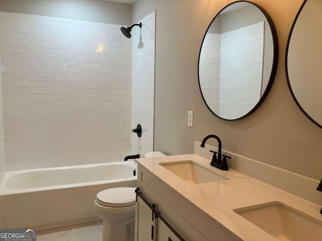 full bathroom with tiled shower / bath, vanity, and toilet