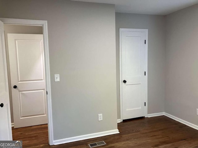 unfurnished bedroom with dark wood-type flooring