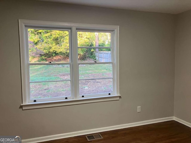 unfurnished room with dark hardwood / wood-style floors and plenty of natural light