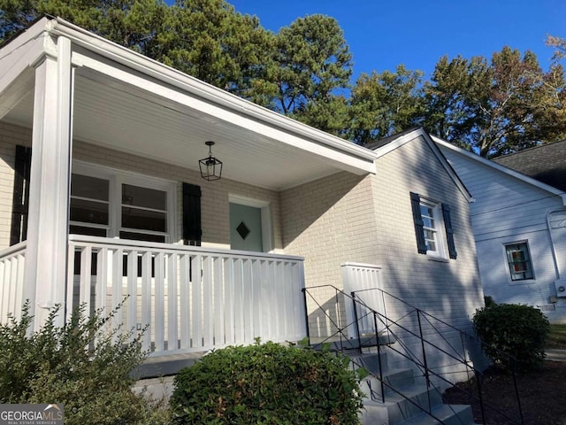 view of exterior entry featuring covered porch