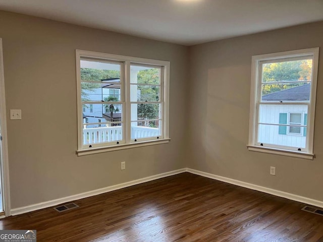 empty room with dark hardwood / wood-style flooring