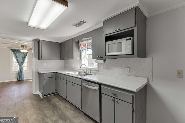 kitchen with dishwasher, gray cabinetry, a healthy amount of sunlight, white microwave, and sink