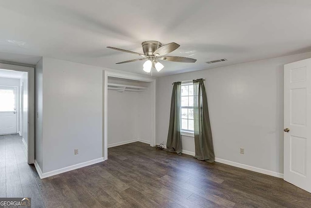 unfurnished bedroom with dark hardwood / wood-style floors, a closet, and ceiling fan