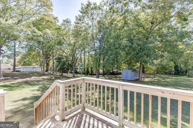 wooden deck with a storage shed and a lawn