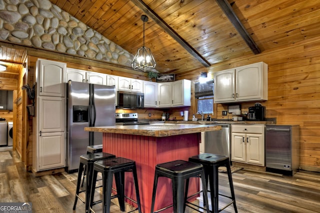 kitchen featuring white cabinetry, a center island, dark wood-type flooring, a breakfast bar area, and appliances with stainless steel finishes