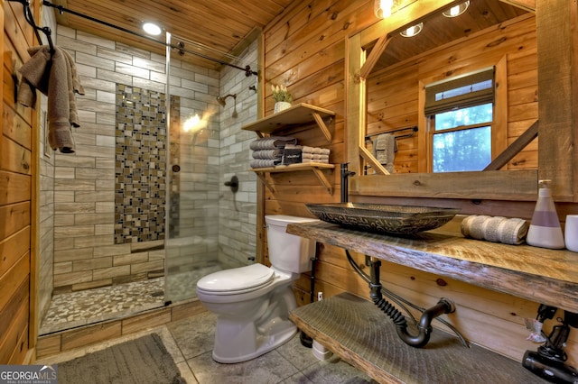 bathroom featuring sink, an enclosed shower, wooden ceiling, and wood walls