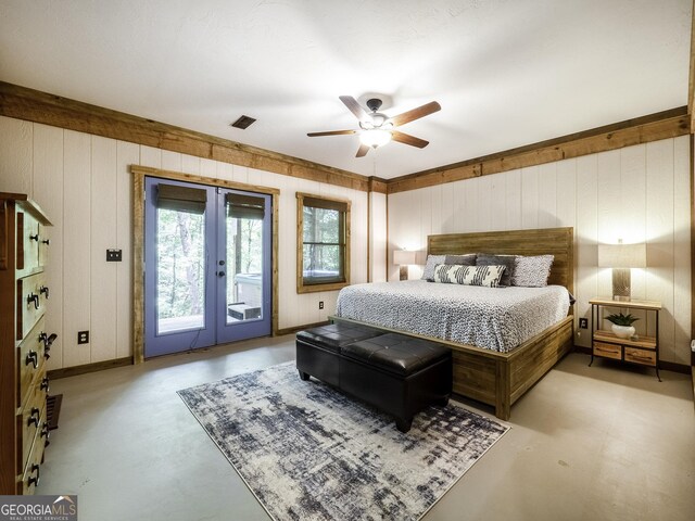 bedroom featuring ceiling fan, wood walls, access to exterior, and french doors