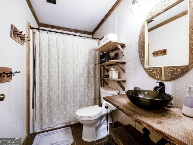 bathroom with a shower with curtain, toilet, crown molding, and sink