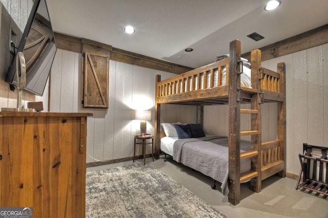 bedroom featuring wood walls