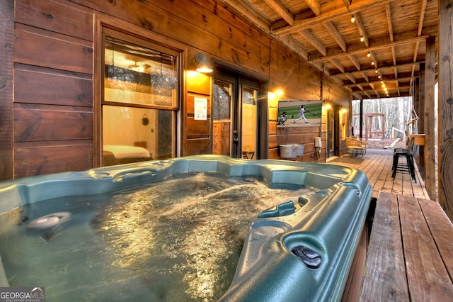 recreation room featuring wood-type flooring, a jacuzzi, and wooden walls