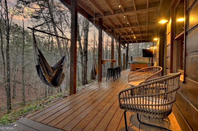 deck at dusk with a hot tub