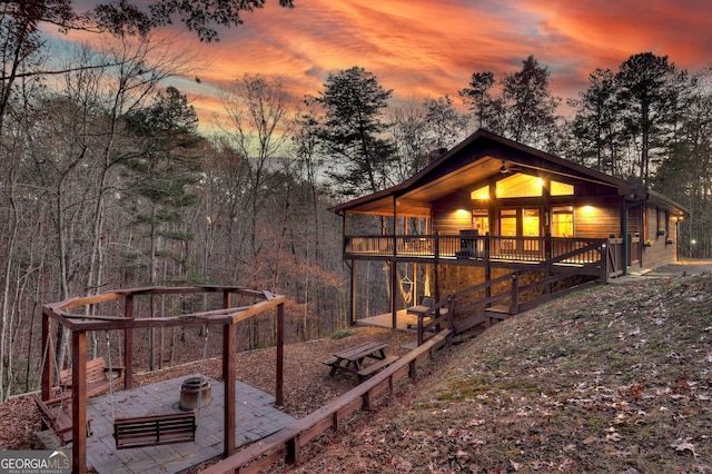 yard at dusk featuring a deck and a patio