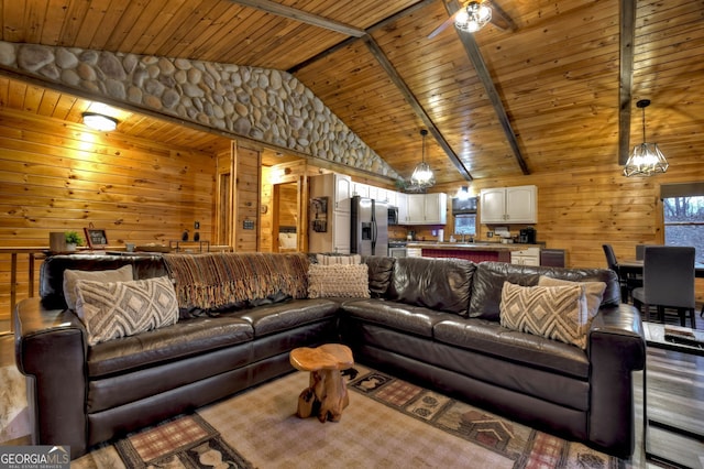 living room featuring wood ceiling, wooden walls, sink, high vaulted ceiling, and beamed ceiling