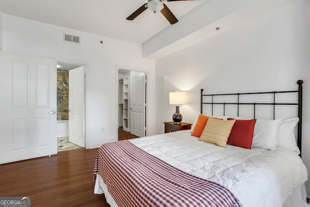 bedroom with a spacious closet, ceiling fan, ensuite bathroom, and dark hardwood / wood-style flooring