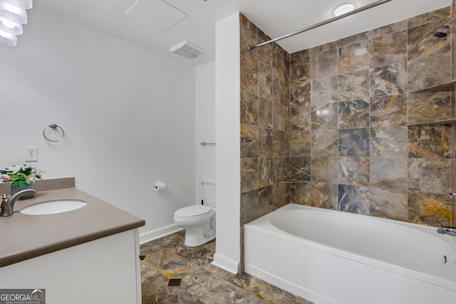 full bathroom featuring vanity, tiled shower / bath combo, and toilet