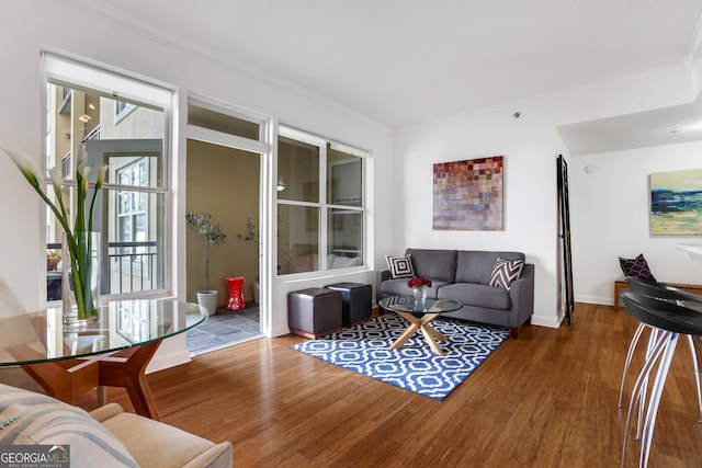 living room featuring crown molding, a healthy amount of sunlight, and hardwood / wood-style flooring