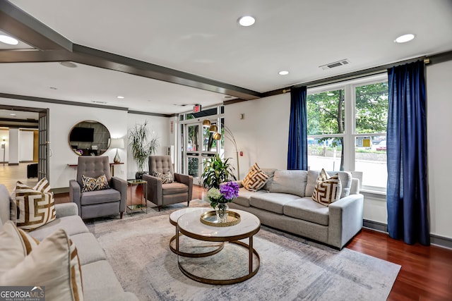 living room featuring dark wood-type flooring and crown molding