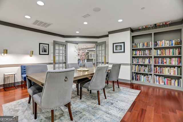 dining room with crown molding, wood-type flooring, and french doors