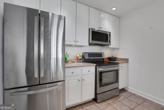 kitchen featuring appliances with stainless steel finishes, white cabinetry, and light tile patterned floors