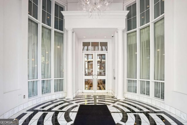 unfurnished sunroom with ornate columns and an inviting chandelier