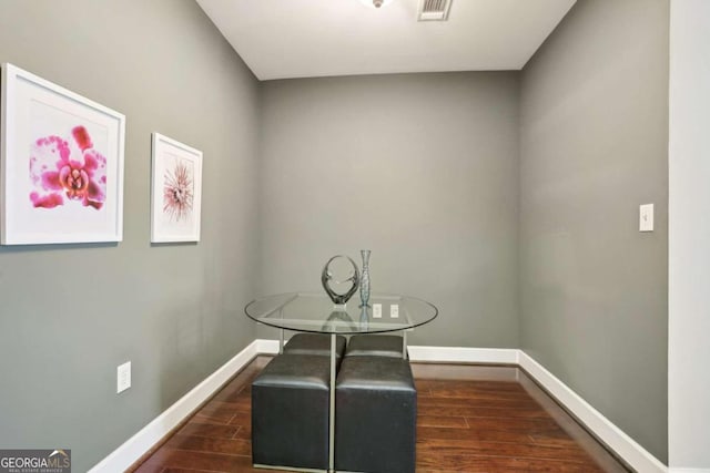 unfurnished dining area with dark wood-type flooring