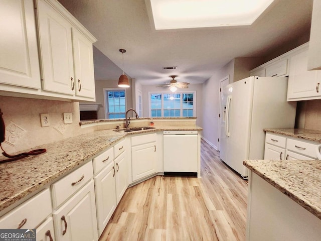 kitchen featuring light hardwood / wood-style flooring, sink, pendant lighting, white cabinetry, and white appliances