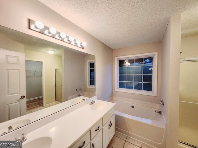 bathroom with vanity, a textured ceiling, independent shower and bath, and tile patterned flooring