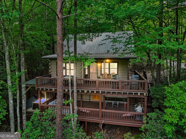 rear view of house featuring metal roof and a wooden deck