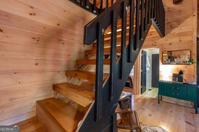 stairway featuring wooden walls and wood-type flooring