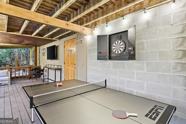 playroom featuring concrete block wall and wood finished floors