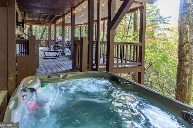 wooden deck with an outdoor hot tub