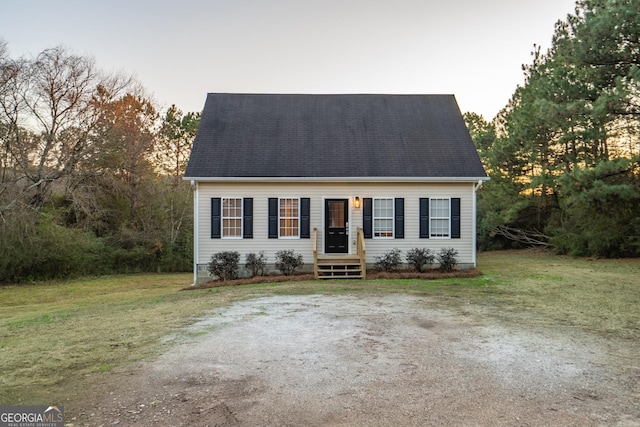 cape cod home with a front lawn