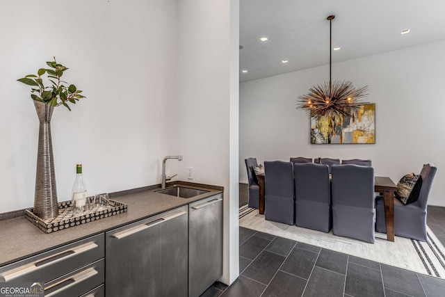 kitchen with recessed lighting, dark tile patterned flooring, a sink, stainless steel dishwasher, and dark countertops