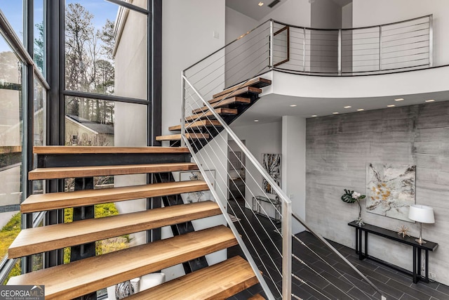 stairway featuring a towering ceiling