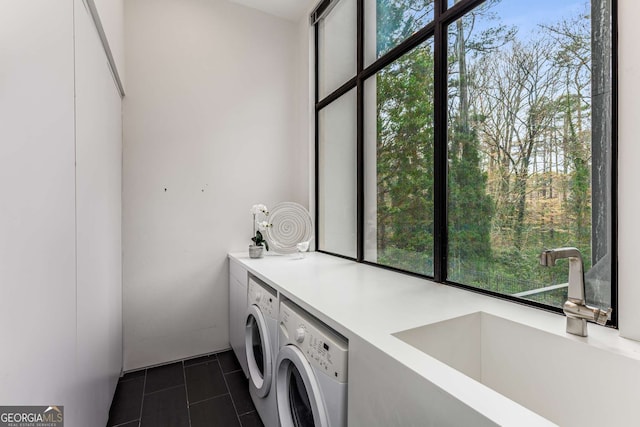 laundry room featuring laundry area, separate washer and dryer, a sink, and dark tile patterned flooring