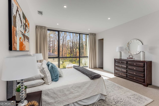 carpeted bedroom featuring expansive windows, visible vents, and recessed lighting