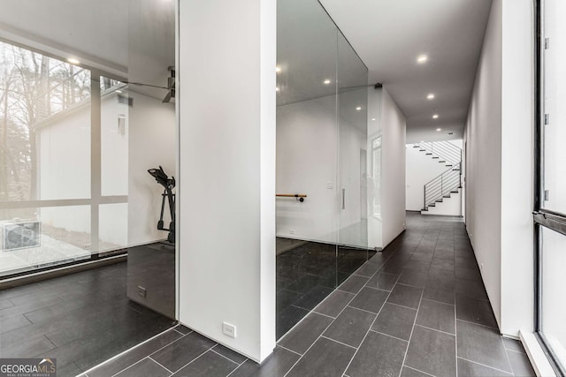 hall featuring dark tile patterned floors, stairway, and recessed lighting