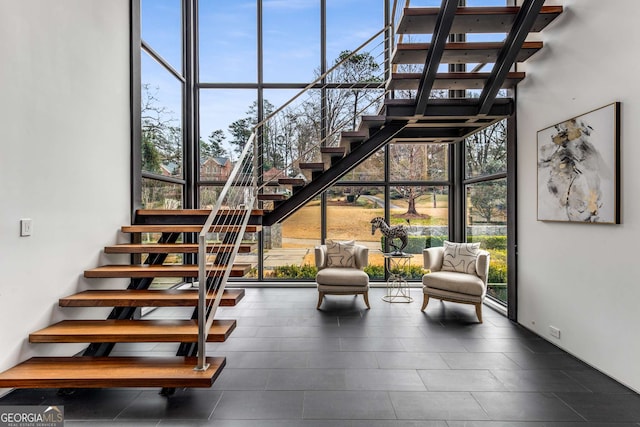 stairs featuring floor to ceiling windows and a towering ceiling