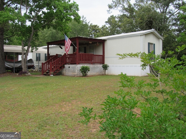 view of front facade with a front lawn and a wooden deck