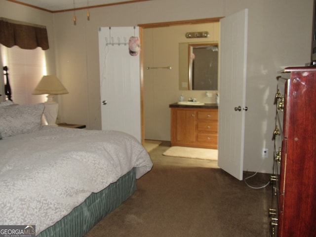 carpeted bedroom with ornamental molding and ensuite bath