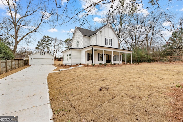 modern farmhouse featuring covered porch, an outbuilding, and a garage