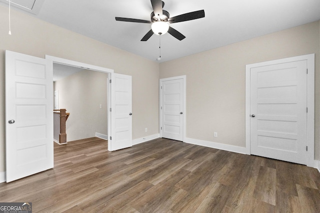 unfurnished bedroom featuring ceiling fan and dark wood-type flooring