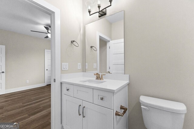 bathroom with wood-type flooring, vanity, toilet, and ceiling fan