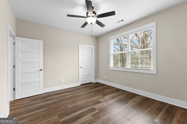 unfurnished bedroom with ceiling fan and dark hardwood / wood-style floors