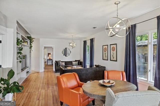 dining space featuring light hardwood / wood-style floors and an inviting chandelier