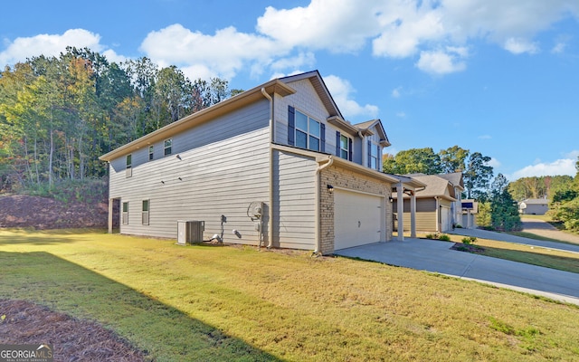 view of side of property with central AC unit, a garage, and a lawn