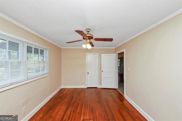 unfurnished bedroom featuring crown molding, a textured ceiling, dark wood-type flooring, and ceiling fan