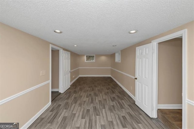 basement with dark hardwood / wood-style floors and a textured ceiling