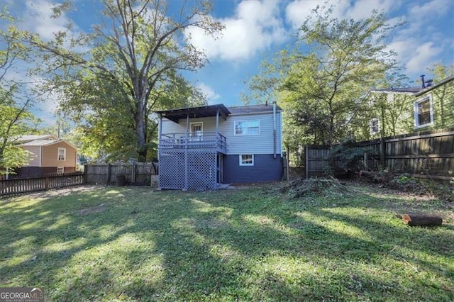 back of property with a deck and a lawn