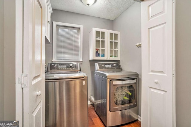 washroom featuring dark hardwood / wood-style floors, a textured ceiling, and washer and clothes dryer